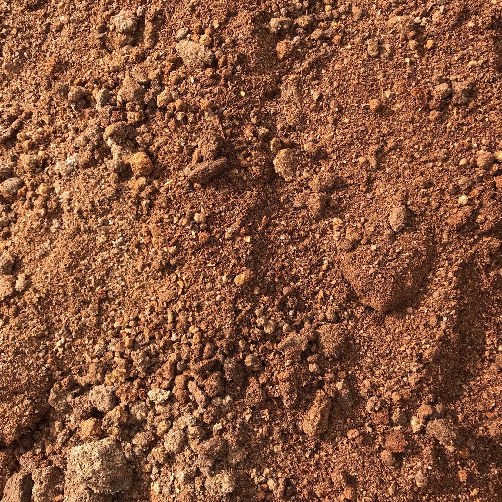 Overhead view of an orange-ish pile of mushroom compost.