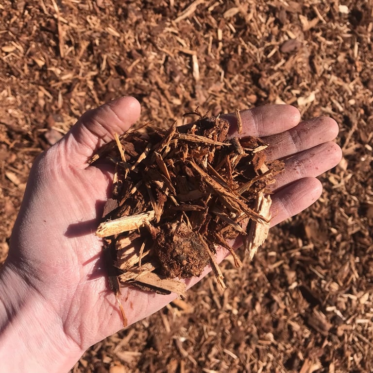Image showing shredded fir bark mulch texture with a hand for scale.