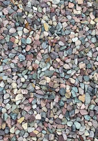 Overhead image that shows the texture of a gray, purple and reddish toned river rock that has been fractured into smaller pieces.