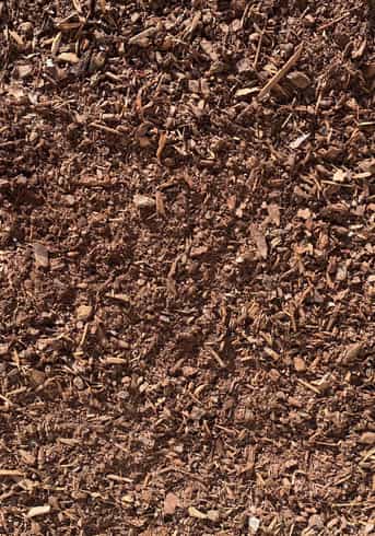 Overhead image showing a dark brown and woody mulch product with small pieces, commonly referred to as soil pep.