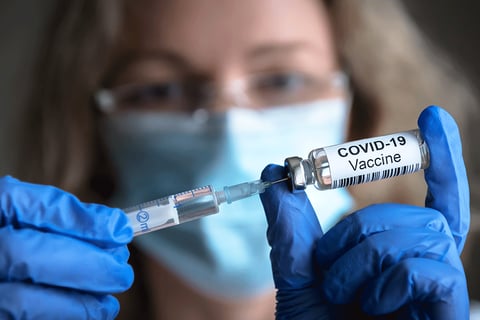 COVID-vaccine being taken into a needle.