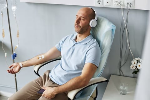 A man receiving an iron infusion in a chair.
