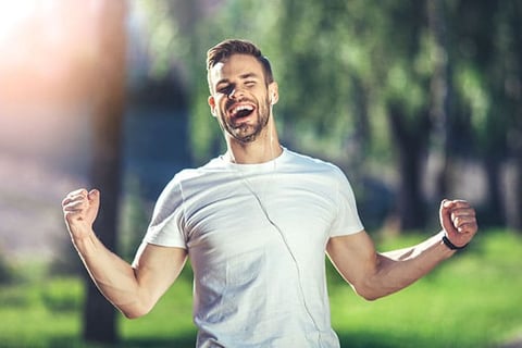 A man expressing joy by double fist pumping the air.