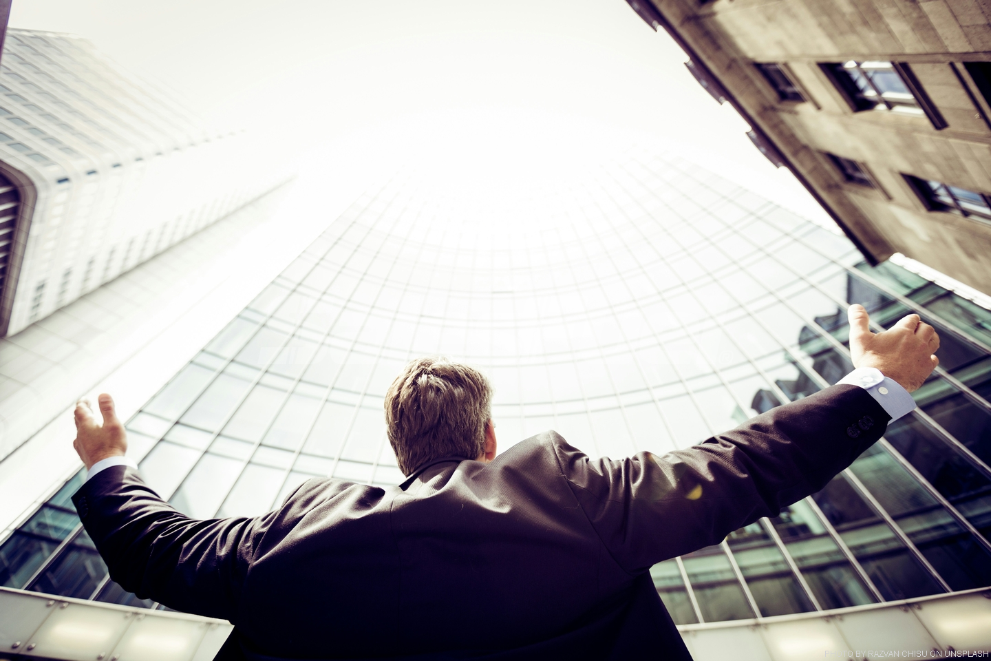 man looking up at building