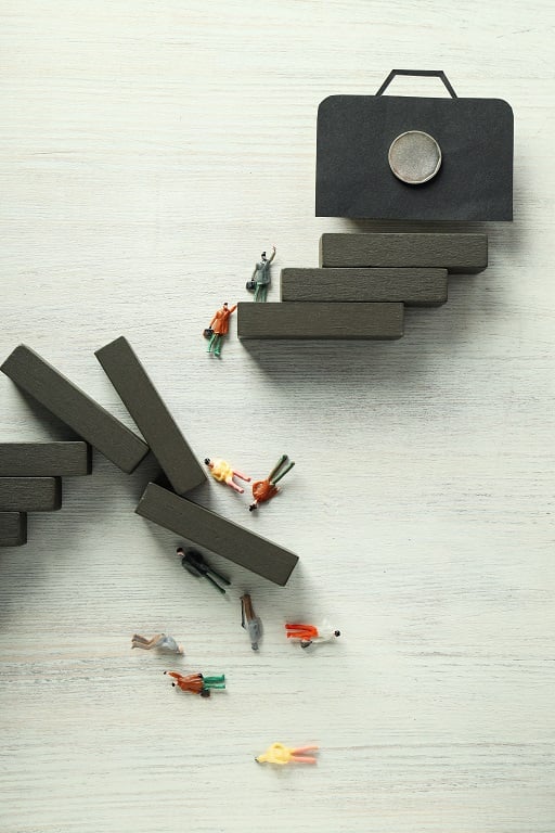 A small group of people on a ladder with a briefcase on top exploring new type of magnetism