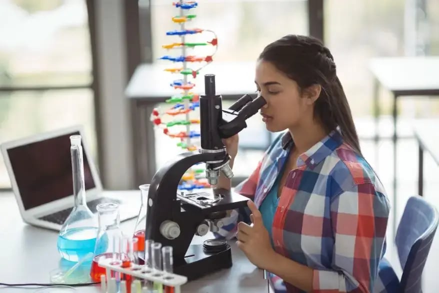 A Teen is Observing Material Structure Under Microscope