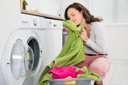 Frau riecht an frisch gewaschener Wäsche