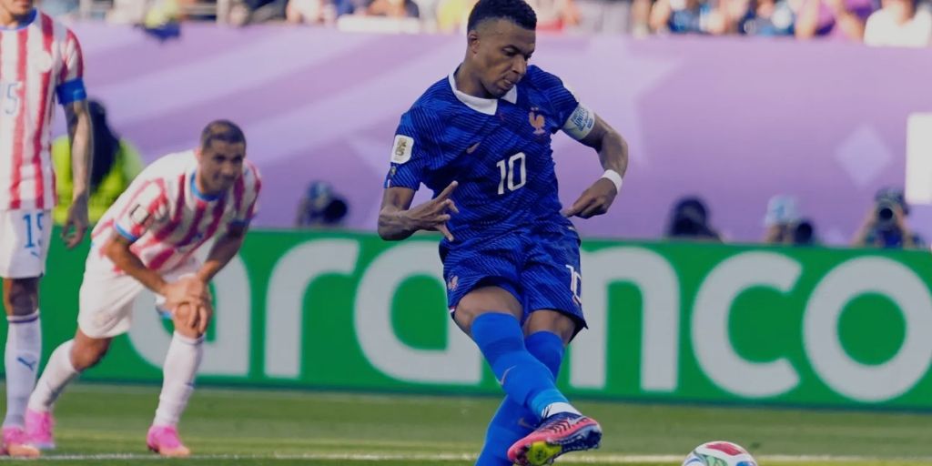 France forward Kylian Mbappe scoring a penalty at the 2026 World Cup against Paraguay with a Paraguayan player in the background