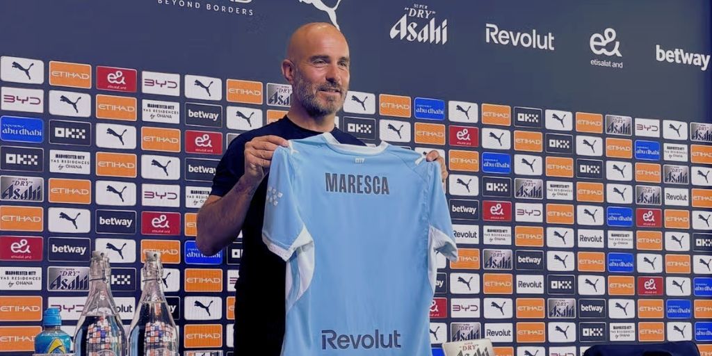 Enzo Maresca holding up a Manchester City jersey at his unveiling