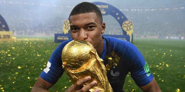 Kylian Mbappe posing with the World Cup after winning the 2018 version