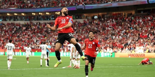 Mo Salah leaping to celebrate a goal as teammate Omar Marmoush comes over to celebrate with him at the 2026 World Cup