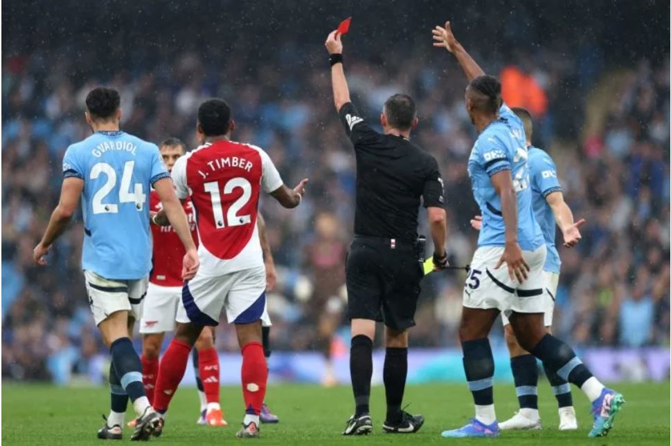 Michael Oliver issuing Leo Trossard a red card