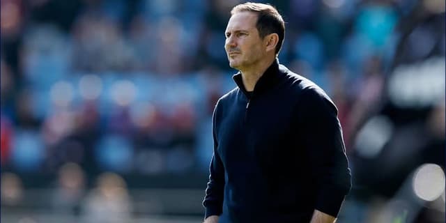 Frank Lampard staring off into the distance with a blurred out stadium behind him