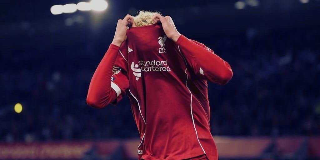 Liverpool player covering face with shirt after a disappointing result