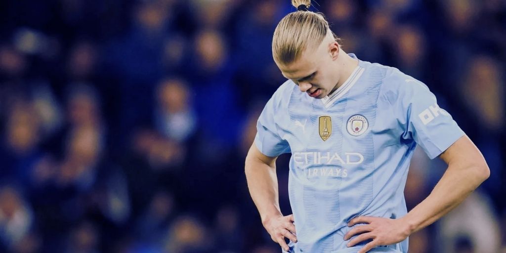 Erling Haaland looking dejected in a Manchester City light blue Etihad-sponsored kit during a Premier League match