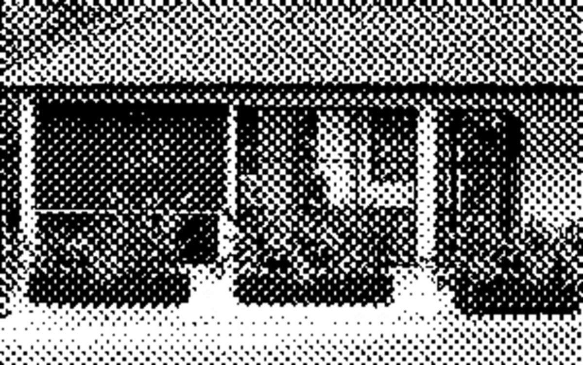 An open kitchen with a wide custom wood-fire grill at the centre, racks of meat hanging above the heat, and a long counter where guests watch the cooks work