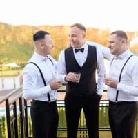 Groomsmen chatting at a wedding with drinks. Perfect for wedding guest book ideas and collecting wedding photos.