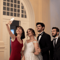 Wedding guests taking a selfie. Perfect for a wedding guest book with a QR code to collect wedding photos.