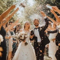 Joyful couple exits ceremony, capturing memories with wedding guest book and QR code to collect wedding photos.