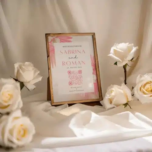 Wedding guest book with QR code surrounded by roses, perfect for collecting memorable wedding photos seamlessly.