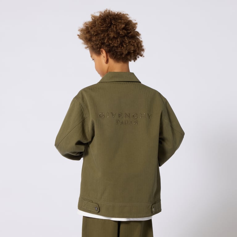 A child in an olive Givenchy jacket, photographed from behind