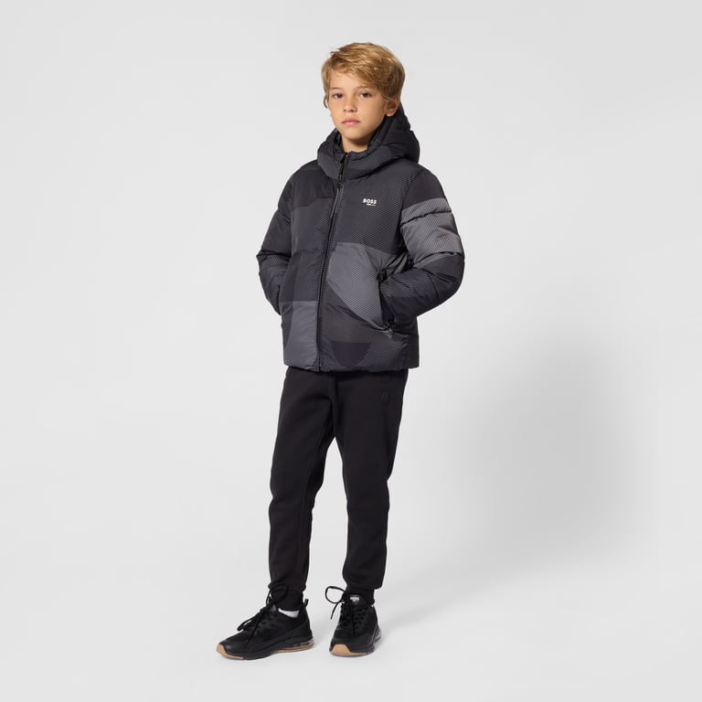 A boy in a black Boss padded puffer jacket and joggers