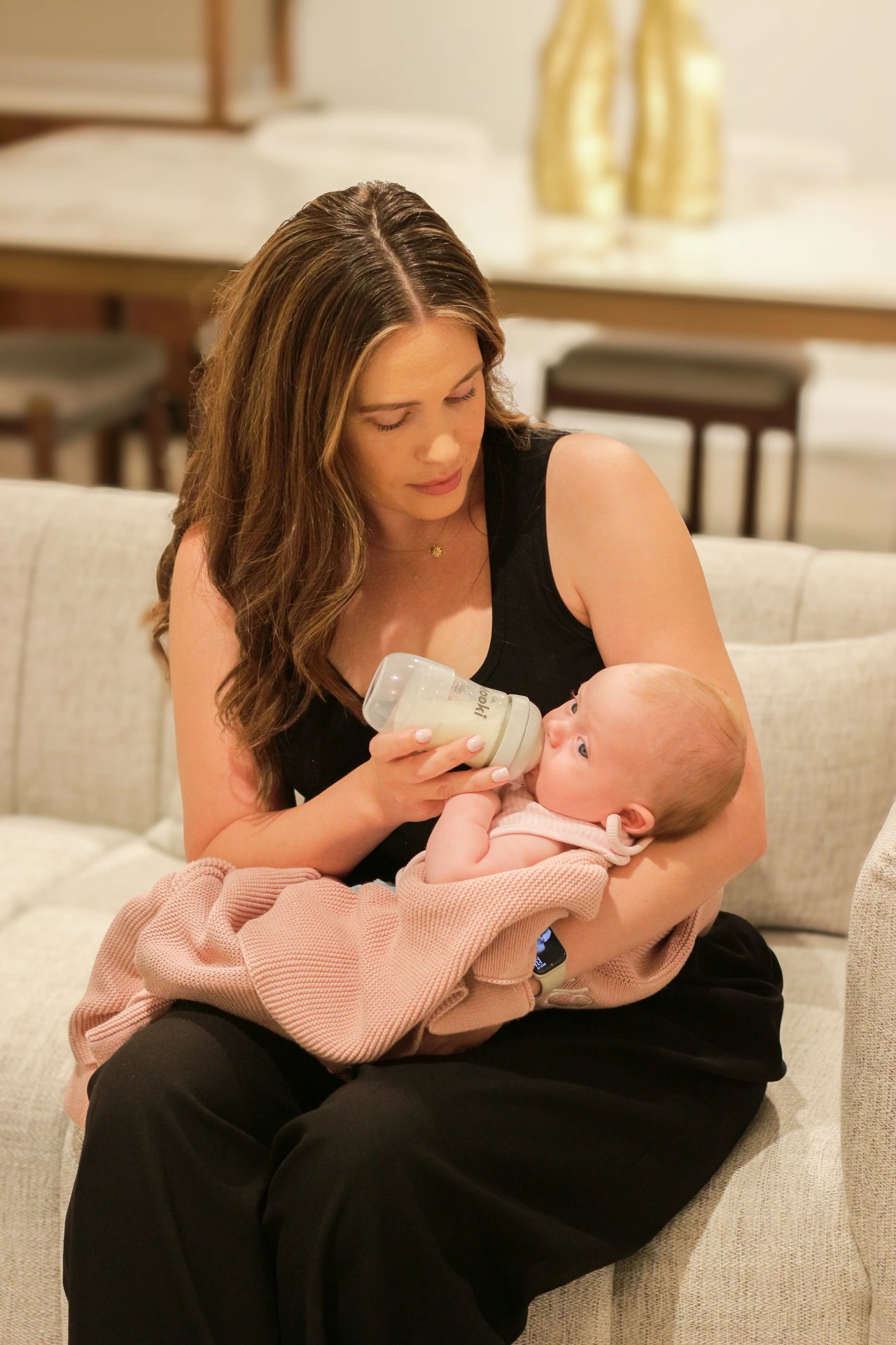 Mother bottle-feeding baby with Mooki