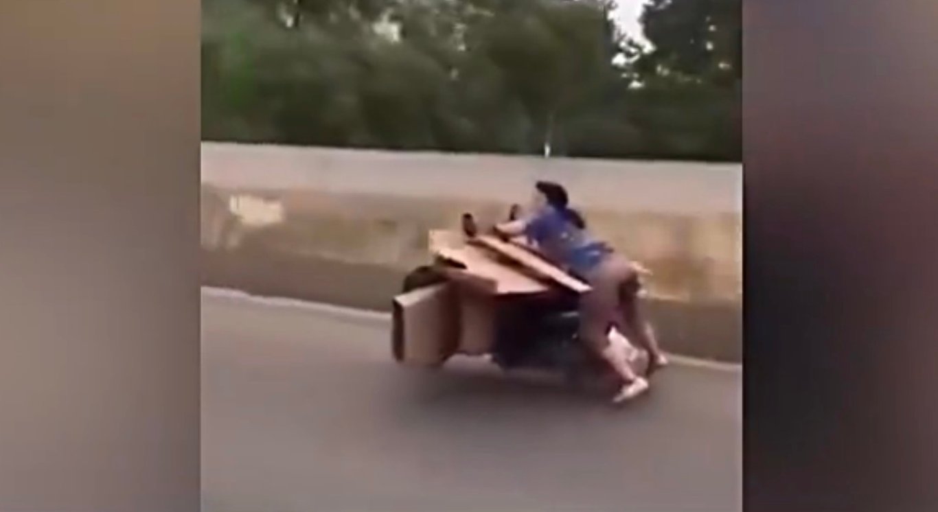 Feature image of Watch: Chinese Woman Drives Motorcycle While Sprawled Atop Boxes