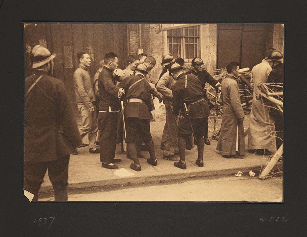 A photograph by Sir Victor Sassoon shows Chinese civilians at a checkpoint operated by Imperial Japanese soldiers