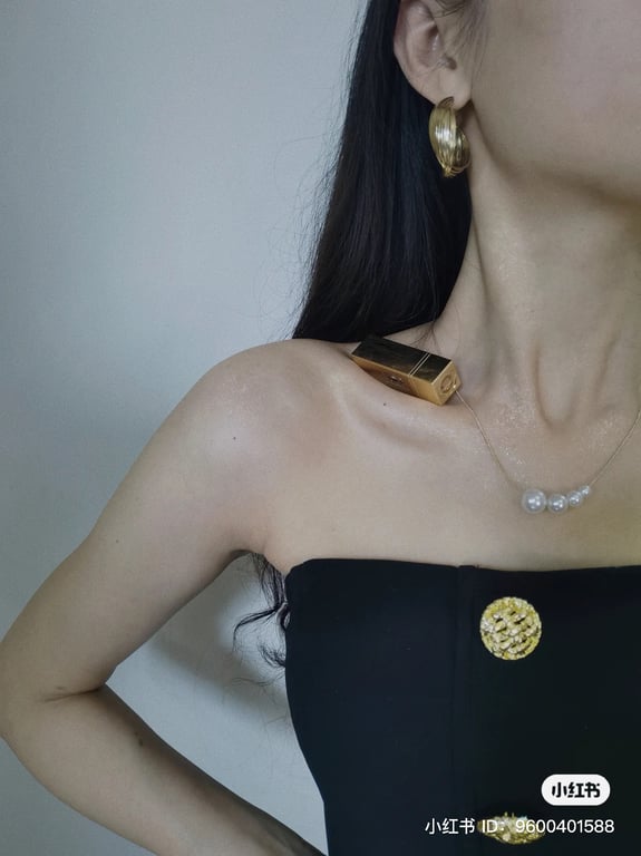 a woman balances lipstick on her collarbone