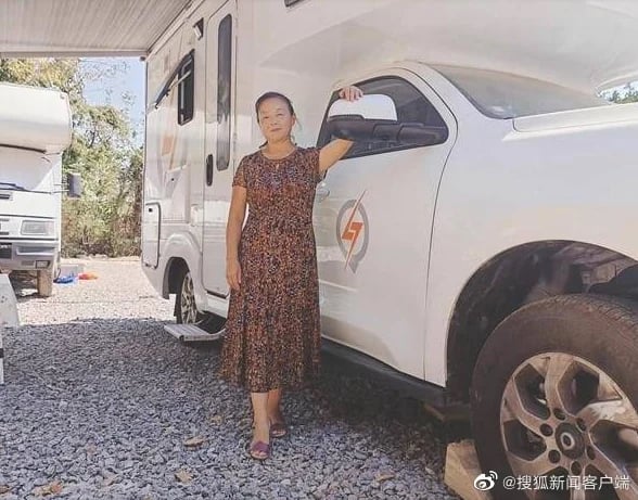 Su Min posing in front of a truck