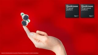 O pereche de căști wireless balansându-se pe vârful unui deget în fața unui fundal roșu alături de brandingul Qualcomm S7.