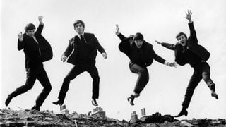 O fotografie alb-negru cu toți cei patru membri ai trupei The Beatles sărind în aer