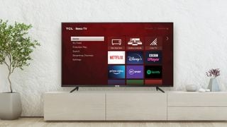 Un televizor pe un suport afișând interfața sistemului de operare Roku
