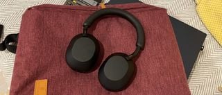 Sony WH-1000XM5 negre pe un material roșu