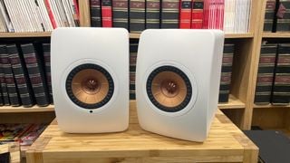 KEF LS50 Wireless II în finisaj alb pe un raft de lemn