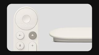 Telecomanda albă Google TV Streamer de aproape, cu cutia de streaming în fundal.