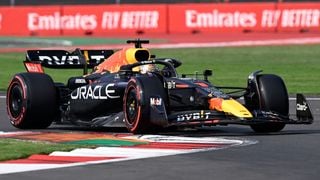 Pilotul olandez Max Verstappen de la Red Bull Racing ia o curbă pe circuit în mașina sa F1 albastru închis de miezul nopții.