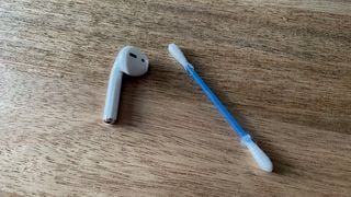 O cască AirPod și un bețișor de urechi