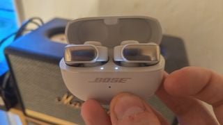 Bose Ultra Open Earbuds ținute în mână