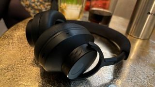 O pereche neagră de căști Cambridge Audio Melomania P100 pe o masă