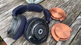 Căști wireless Dyson OnTrac pe masă de lemn cu capace de urechi îndepărtate
