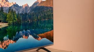 Amazon Fire TV din seria 4 pe o unitate de lemn cu un lac și pădure pe ecran