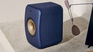 O boxă KEF LSX II albastră pe o suprafață de piatră.