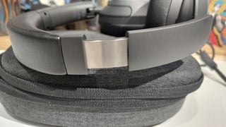 Căști over-ear Earfun Wave Pro așezate pe carcasa de transport, detaliu bandă de cap