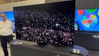 Samsung S95F pe un suport gri cu lumini pe ecran