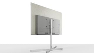 Televizor Loewe Stellar pe fundal alb cu panoul din spate de beton orientat în față