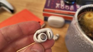 Bose Ultra Open Earbuds ținute în mână