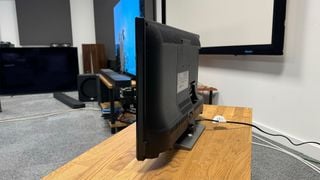 Televizor Toshiba 24WK3C63DB de 24 de inch, văzut din lateral/spate pe un suport TV