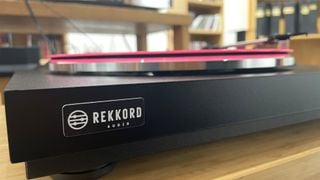 Rekkord Audio F110 văzut din față, arătând logo-ul și un disc roz